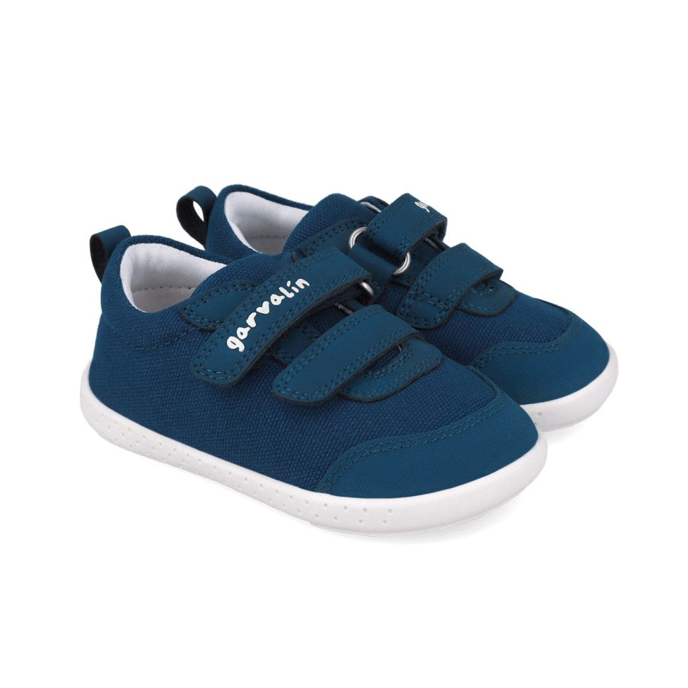 Par de sapatilhas barefoot Garvalín em lona azul, com biqueira larga, fechos de velcro e sola branca antiderrapante.