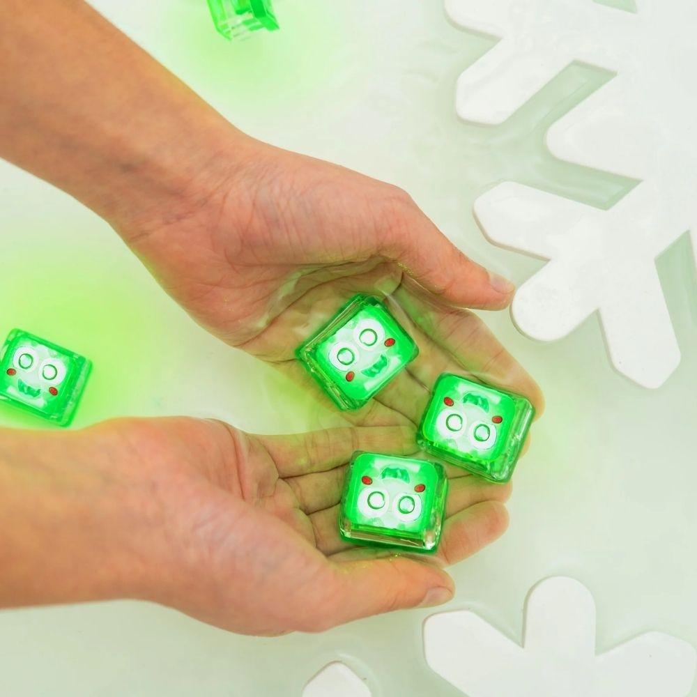 GloPals Cubos de Luz para água 4unid de Natal verdes brilhando nas mãos em água, brincadeira sensorial.