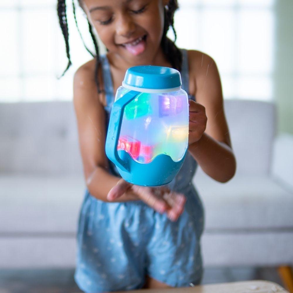 Menina a segurar o Jarro da Calma Sensorial GloPals azul iluminado com água, mostrando a interação sensorial.