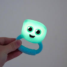 Uma mão a segurar o GloPals Mordedor & Guizo com luz azul, que está aceso, mostrando o efeito de iluminação.