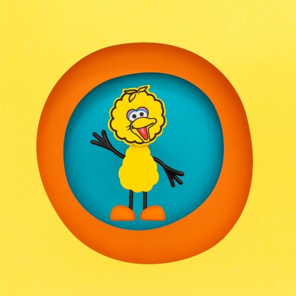 Boneco Poupas GloPals com braços abertos, sorridente, em fundo circular laranja e azul.