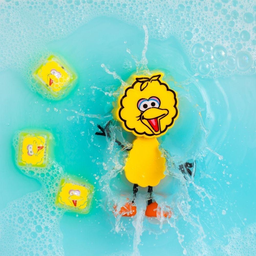 Boneco Poupas GloPals e cubos de luz a brilhar e salpicar em água azul, demonstrando o efeito luminoso.