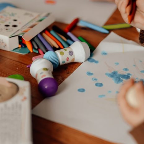 Haku Yoka 5 dot markers em uso por criança pintando pontos azuis em papel. Ideal para criatividade infantil.