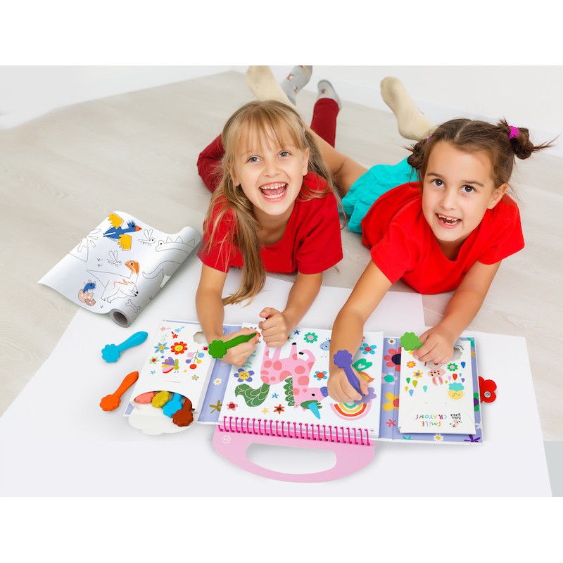 Duas crianças a sorrir e a colorir juntas no chão usando o Kit de colorir Haku Yoka O meu primeiro Kit de colorir Dinossauros.