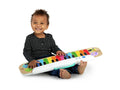Criança sentada a tocar o Teclado Musical Magic Touch da Hape Baby Einstein.