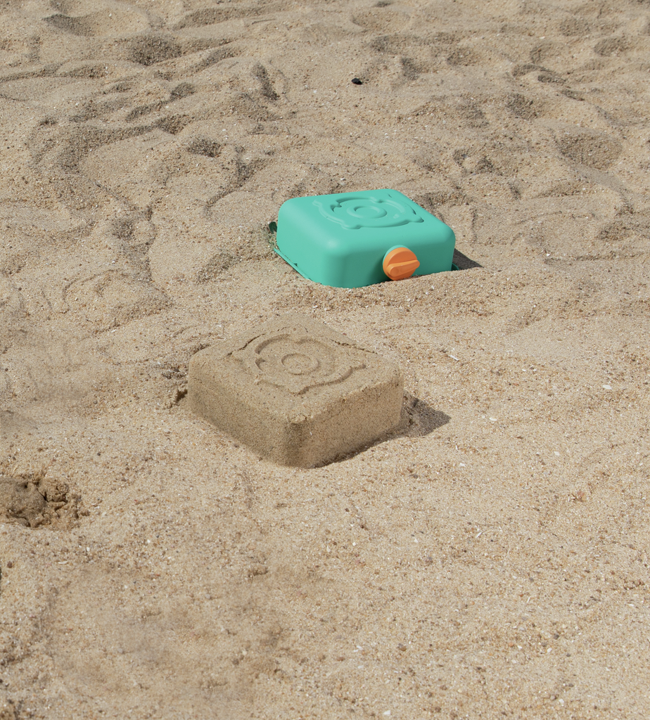 Molde de areia em forma de cozinha feito com o kit Hape na praia.