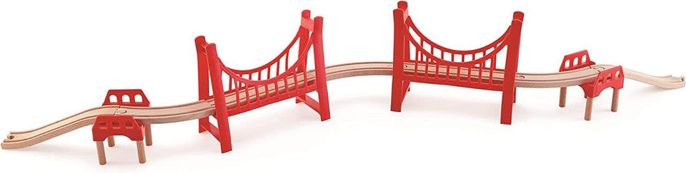 Configuração completa do Hape Kit Extensão Ponte Suspensa, com trilhos de madeira a ligar as duas estruturas de ponte dupla suspensa vermelha.