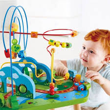 Imagem de ângulo superior mostrando a estrutura completa da mesa de atividades Hape, destacando os diferentes painéis de jogo e a base de madeira robusta.