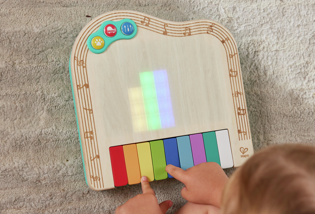 Piano Hape Pixel com luzes ativas enquanto bebe toca.