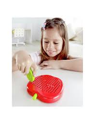 Menina sorridente a interagir com o quadro de desenho magnético Hape em forma de maçã vermelha.