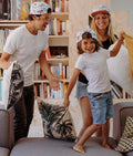 Família (pai, mãe, filho) usa bonés Hello Hossy Aussie a brincar, mostrando tamanhos criança e adulto.