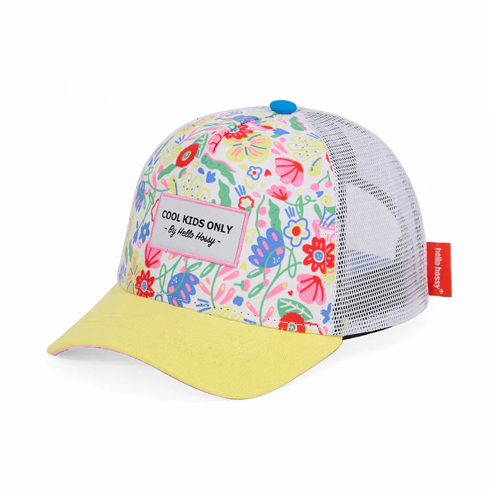 Criança sorridente usa boné infantil Hello Hossy Garden Party com padrão floral colorido e aba amarela.