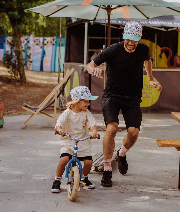 Pai e filho a usar bonés Hello Hossy Jungly a condizer, mostrando o look de família.