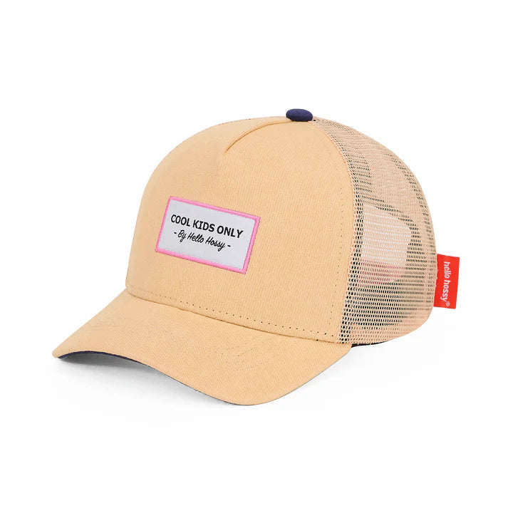 Menina feliz a usar o boné trucker Mini Melba bege da Hello Hossy com etiqueta "Cool Kids Only".