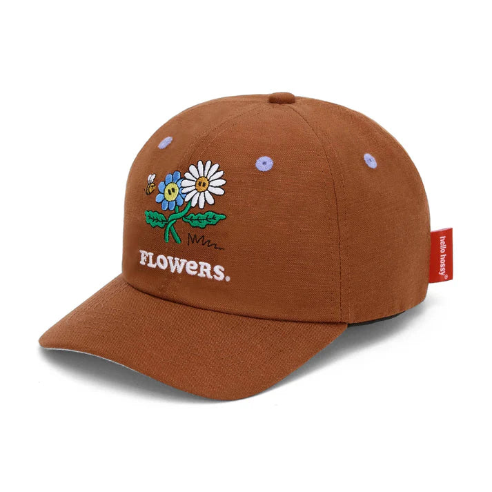 Criança usa boné Hello Hossy Flowers de linho e algodão. Bordado floral colorido. Ideal para bebés/crianças.