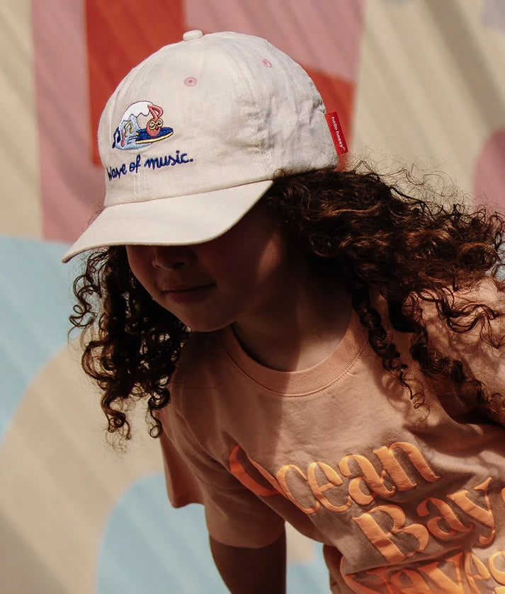 Criança com boné HELLO HOSSY Wave linho algodão. Aba protege do sol, ideal para aventuras ao ar livre.