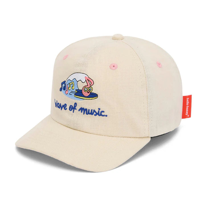 Menina feliz usa boné HELLO HOSSY Wave linho algodão. Design moderno e confortável para crianças.