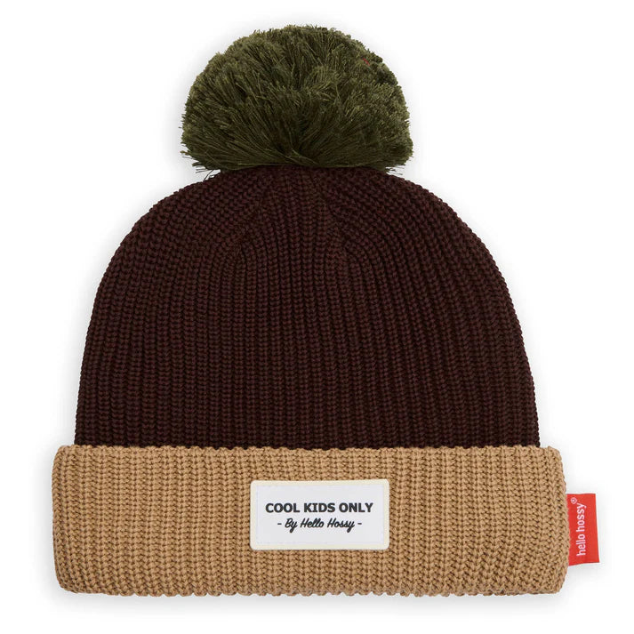 Imagem de estúdio do gorro de malha canelada castanho e bege, com pompom verde musgo e etiqueta frontal "COOL KIDS ONLY".