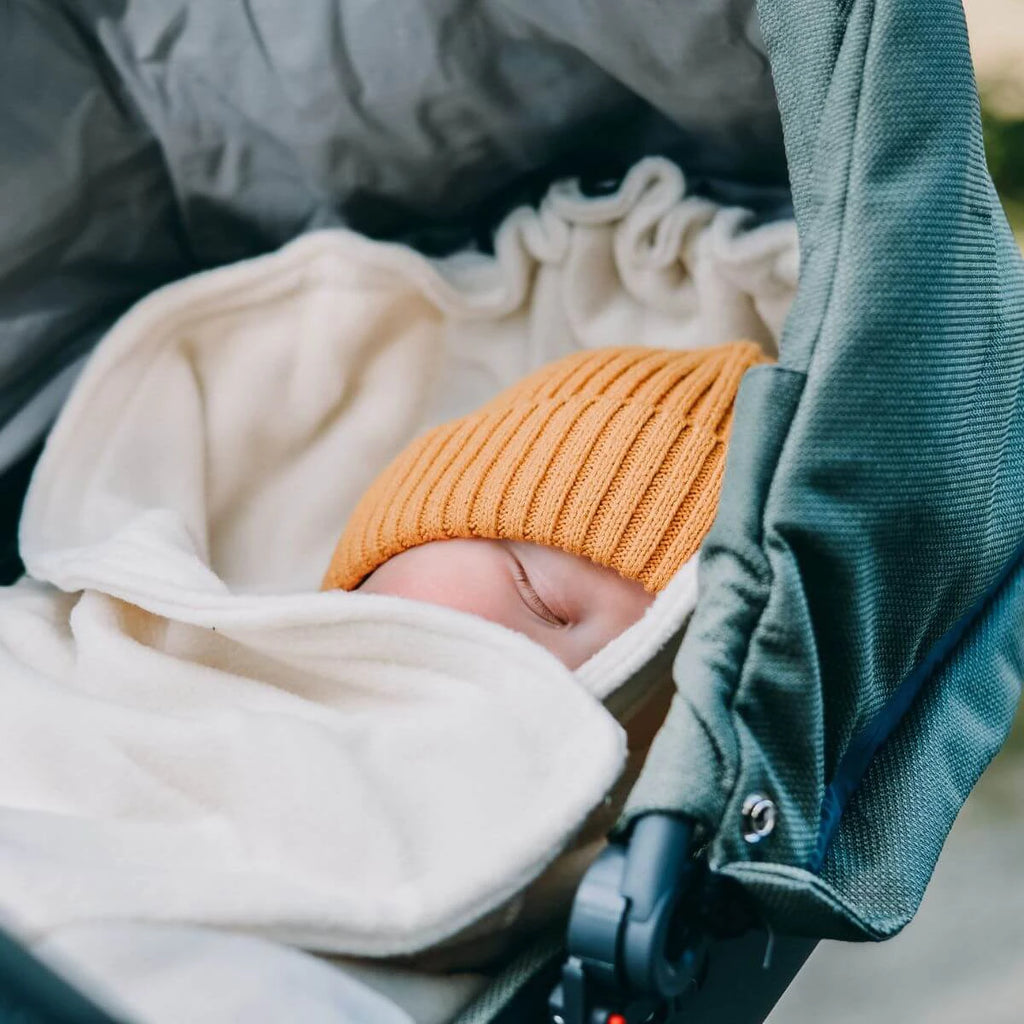 Manta polar Hoppediz creme desdobrada, mostrando a textura suave e as dimensões 80x80 cm, ideal para carrinho.