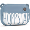 Vista frontal da câmara digital infantil Hoppstar Artist em cor azul denim, destacando o design robusto e a lente principal.