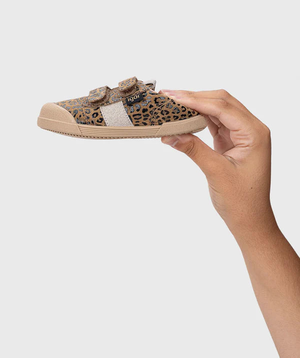 Mão a segurar a sapatilha Igor Barefoot TENNIS LEO MARROW/ BROWN, mostrando o design leve e o padrão leopardo.