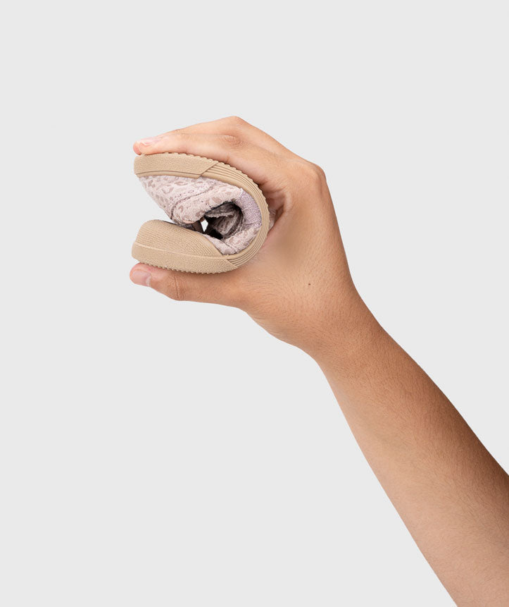 Demonstração da extrema flexibilidade da sola das sapatilhas Igor Barefoot TENNIS LEO ROSA, dobradas ao meio por uma mão.