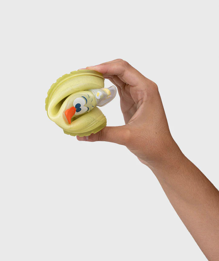 Mão a dobrar a flexível galocha infantil Igor MENDI amarela, demonstrando a maleabilidade do material impermeável.