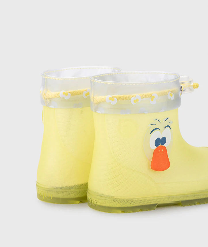Detalhe traseiro das galochas infantis Igor MENDI amarelas, exibindo o design de pato e o rebordo transparente com padrão de flores.