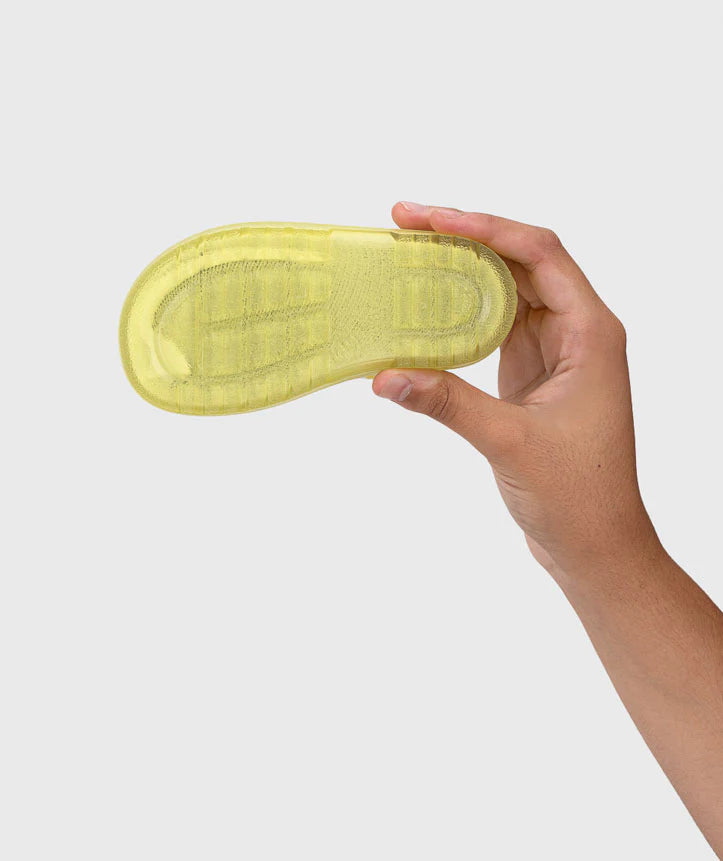 Mão a segurar a sola antiderrapante da galocha Igor MENDI amarela, mostrando o padrão de tração para estabilidade.