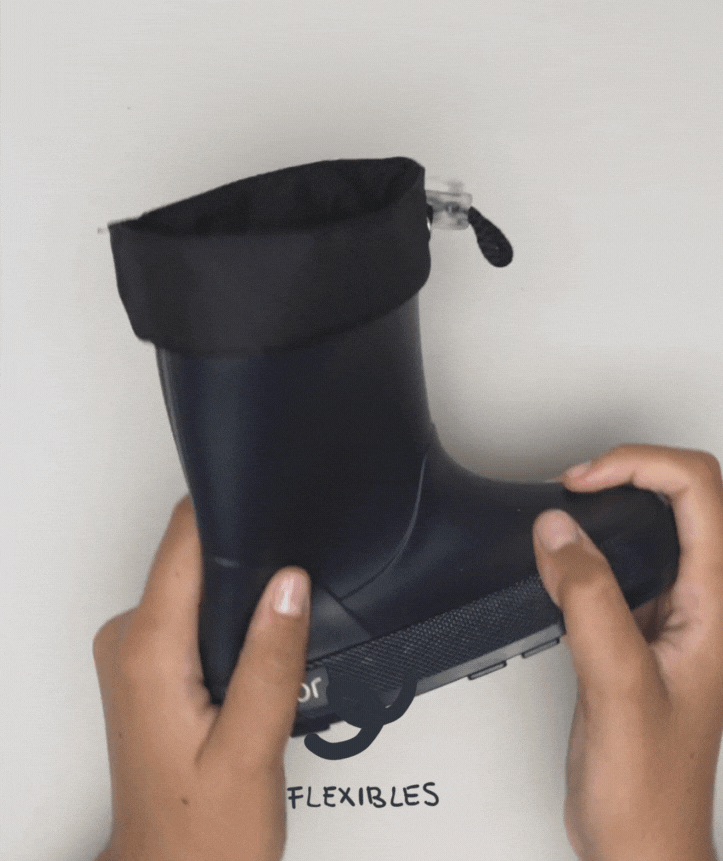 Demonstração da flexibilidade das galochas infantis Igor Yogi Cuello Marino, sendo dobradas por mãos, com a palavra "FLEXIBLES" escrita abaixo.