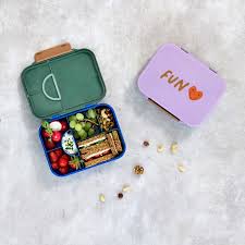 Duas lancheiras Lassig Lunchbox Heart Purple e verde, uma aberta com alimentos organizados, mostrando uso prático.