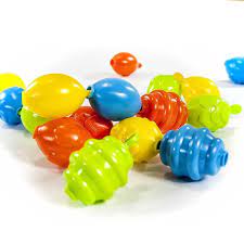 Um conjunto de contas de encaixe Miniland Maxichain em cores vibrantes como amarelo, azul, laranja e verde, espalhadas sobre uma superfície branca, destacando a textura e o formato das peças.