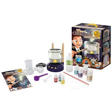 Todos os componentes do kit Buki Caldeirão Mágico dispostos sobre um fundo branco, incluindo o caldeirão, reagentes, utensílios e manual.