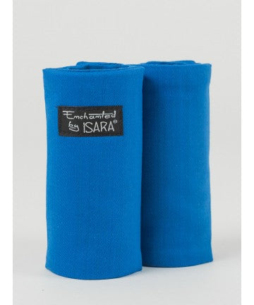 Par de protetores de alças Isara Teething Pads em tecido azul sólido, enrolados, com etiqueta preta "Enchanted by ISARA".