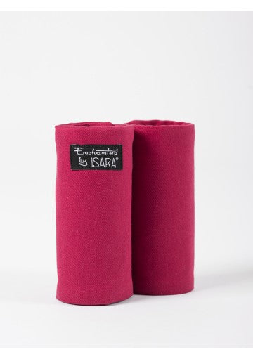 Par de protetores de alças Isara Teething Pads cor magenta escura, enrolados, com etiqueta preta "Enchanted by ISARA".