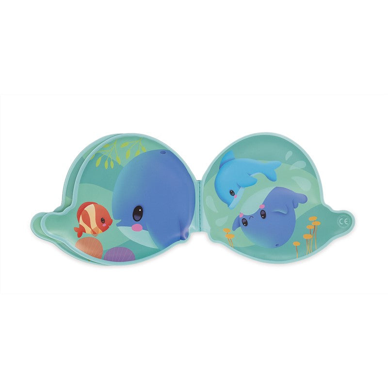 Livro de banho Janod Baleia aberto, mostrando duas páginas com ilustrações de animais marinhos como um golfinho e peixe.