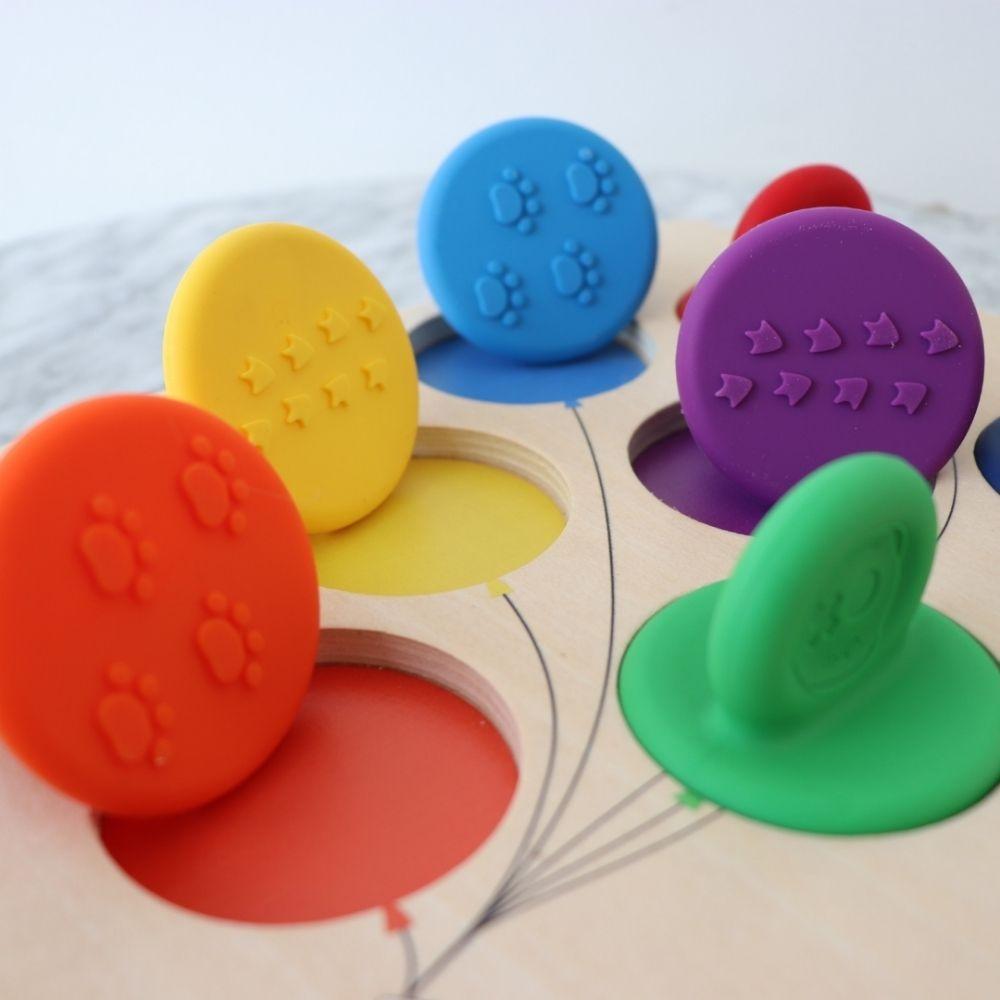 Detalhe das tampas de silicone coloridas do conjunto Jellystone com texturas de pegadas e estrelas na base