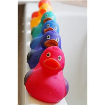 Cinco patos de borracha coloridos (do rosa ao amarelo) alinhados na borda de uma banheira branca, mostrando as cores vibrantes do conjunto.