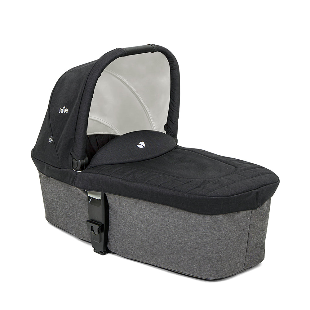 Detalhe da asa de transporte ajustável da alcofa Joie Chrome, em tecido preto, com o logótipo Joie visível.