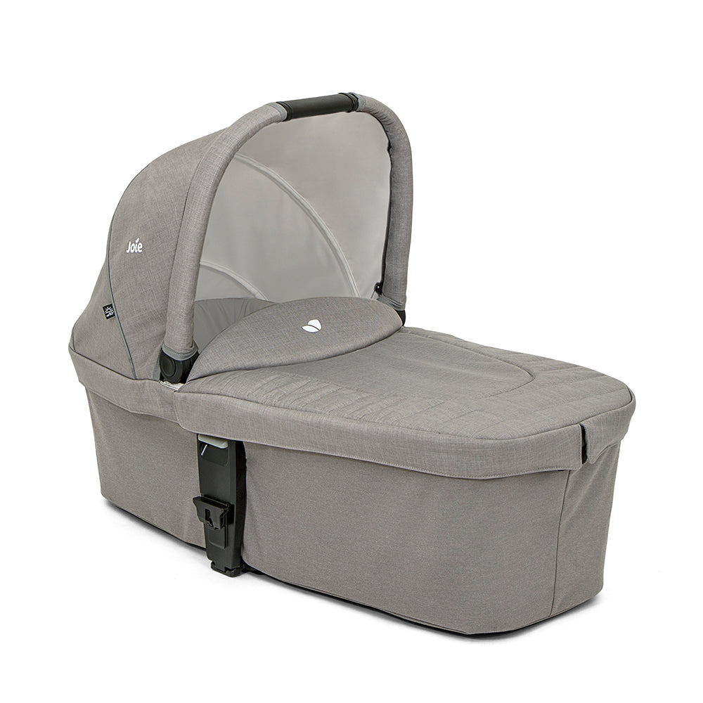 Alcofa Joie Chrome em cor escura, vista lateral, com capota estendida e asa de transporte visível.