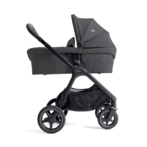 Alcofa Joie Ramble XL cinzenta montada num chassis de carrinho Joie, vista lateral.