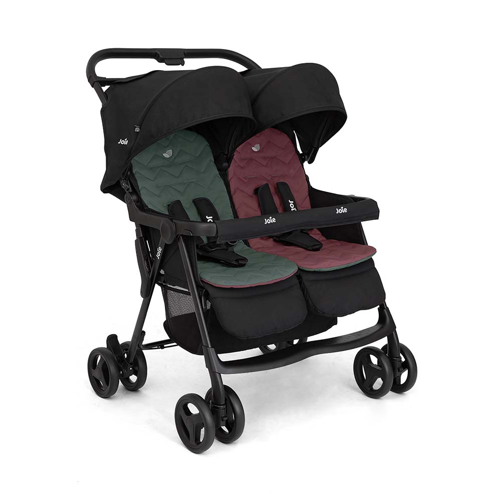 O carrinho Joie Aire™ twin em movimento, com suspensão integral visível nas rodas, garantindo um passeio suave.