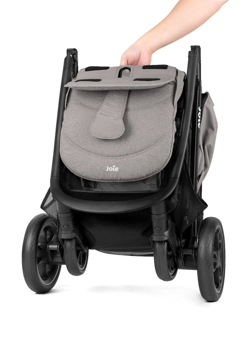 Criança sentada no carrinho Joie Litetrax PRO com arnês de 5 pontos visível, desfrutando do passeio com o mundo à sua frente.