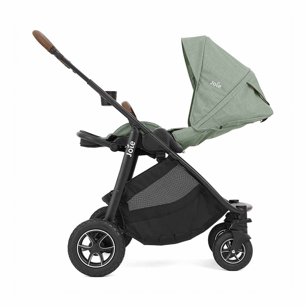 O carrinho Joie Versatrax™ com o guiador ajustado à altura máxima, mostrando o porta-copos lateral.