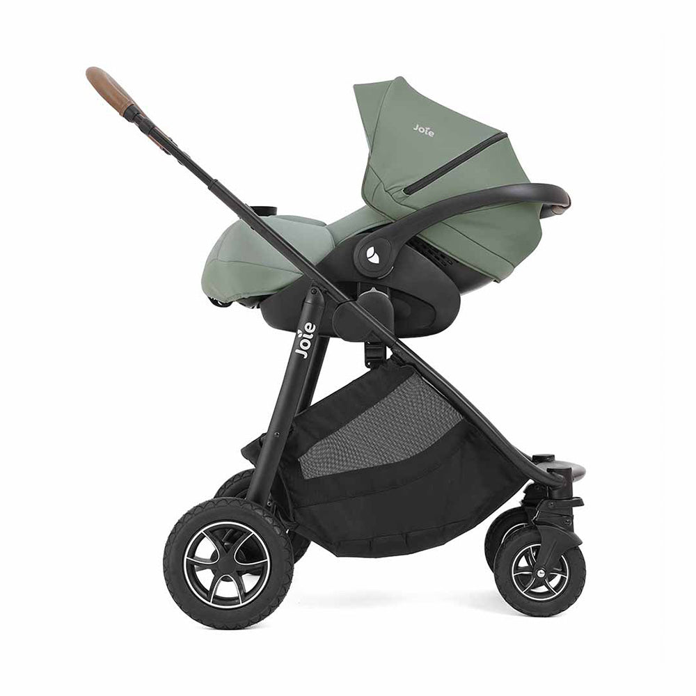 Vista lateral do carrinho Joie Versatrax™ com reclinação total, ideal para recém-nascidos, e cesta de arrumação grande.