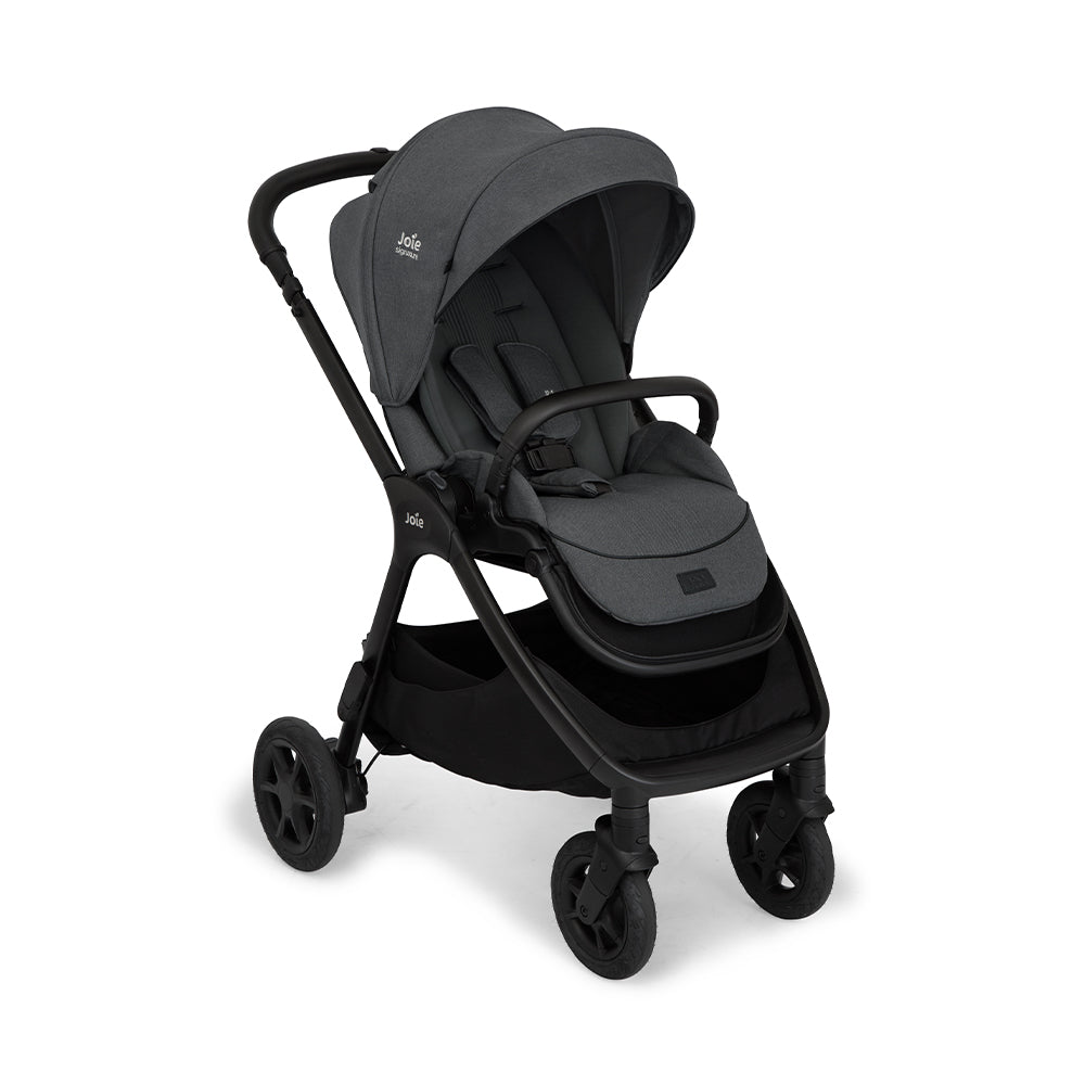 Carrinho Joie Finiti Signature XL cinzento escuro, com assento reversível virado para os pais, mostrando o arnês de 5 pontos e acabamentos premium.