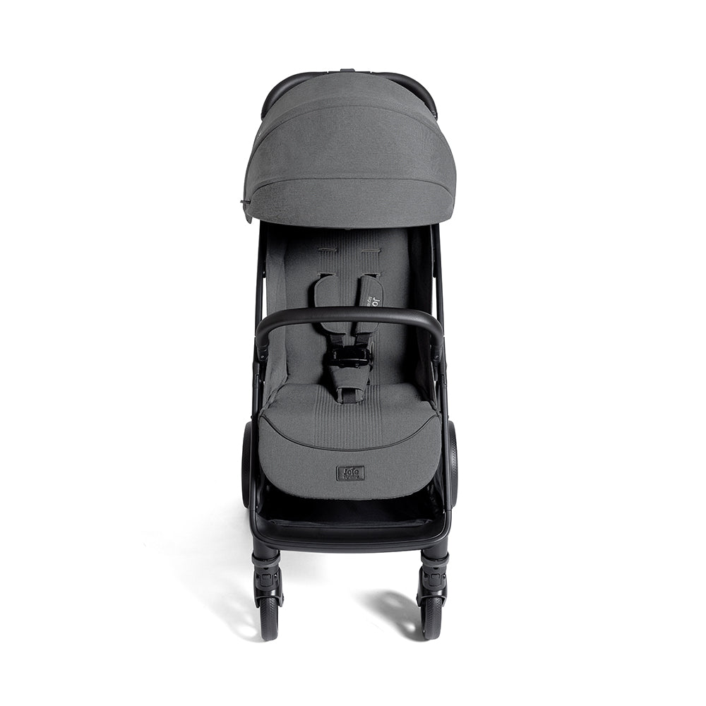 Carrinho de passeio Joie Parcel LX Signature cinzento, visto de frente, com capota estendida e arnês de 5 pontos visível.