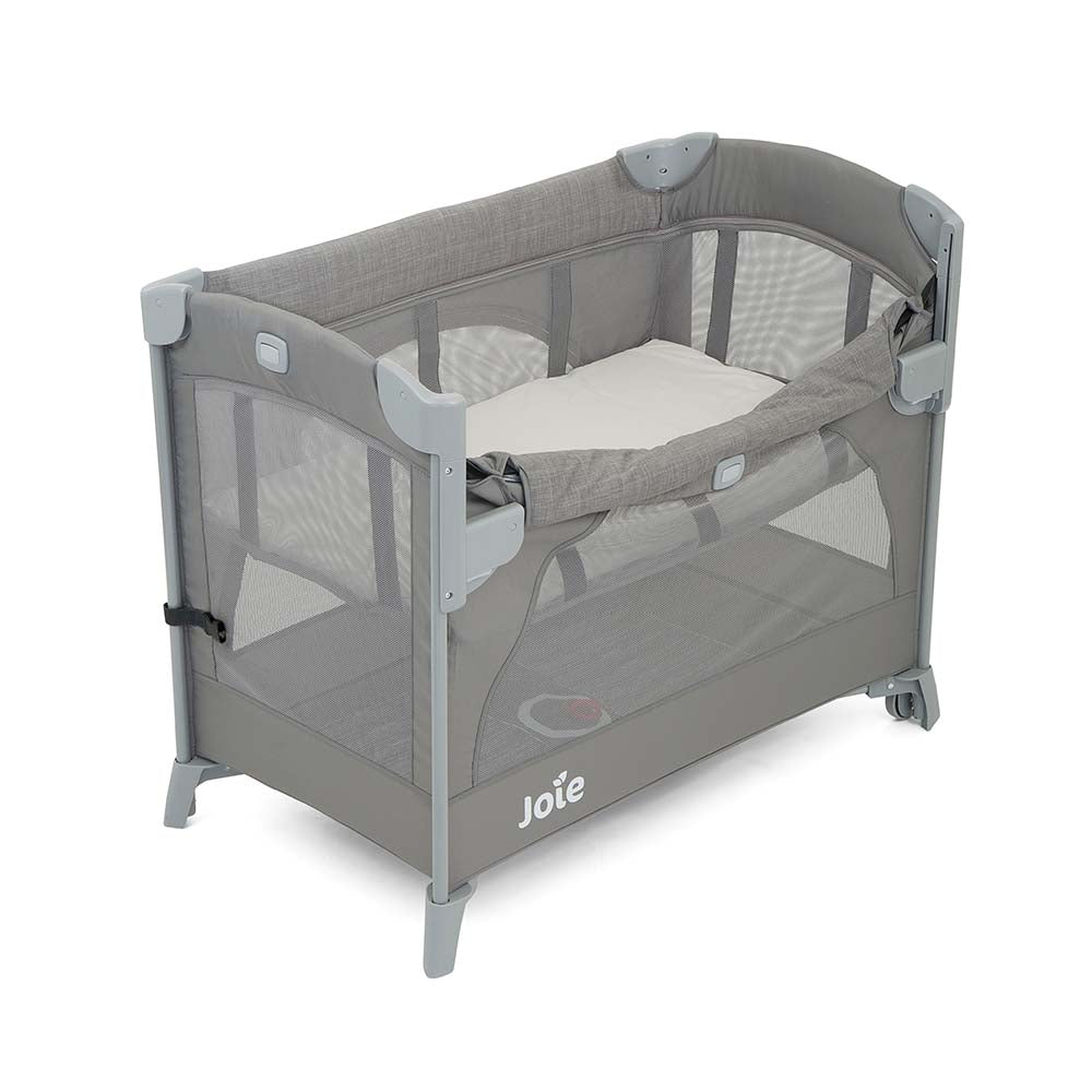 Detalhe da lateral abatível do berço Joie Kubbie Sleep, mostrando a função co-sleeping segura com colchão ao nível da cama dos pais.