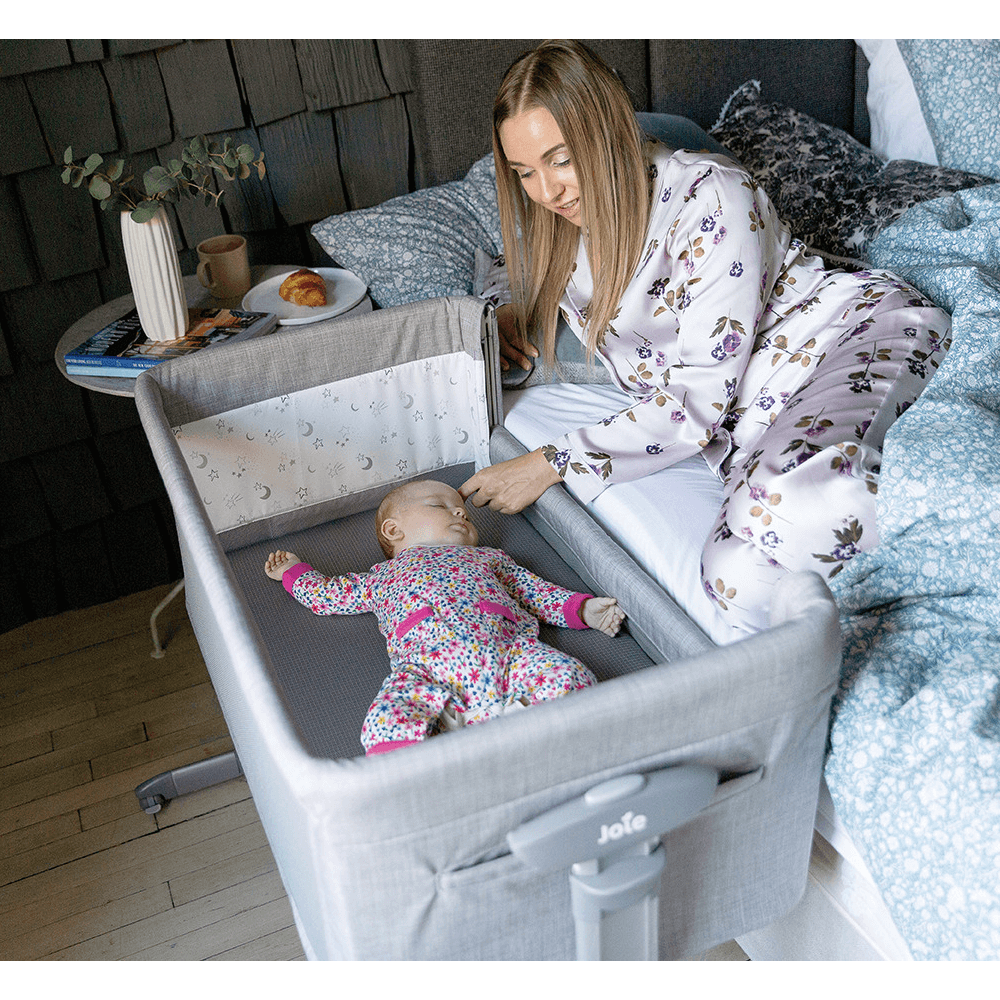 Detalhe da lateral em rede do berço Joie Roomie glide, mostrando a ventilação e a proximidade segura ao colchão.