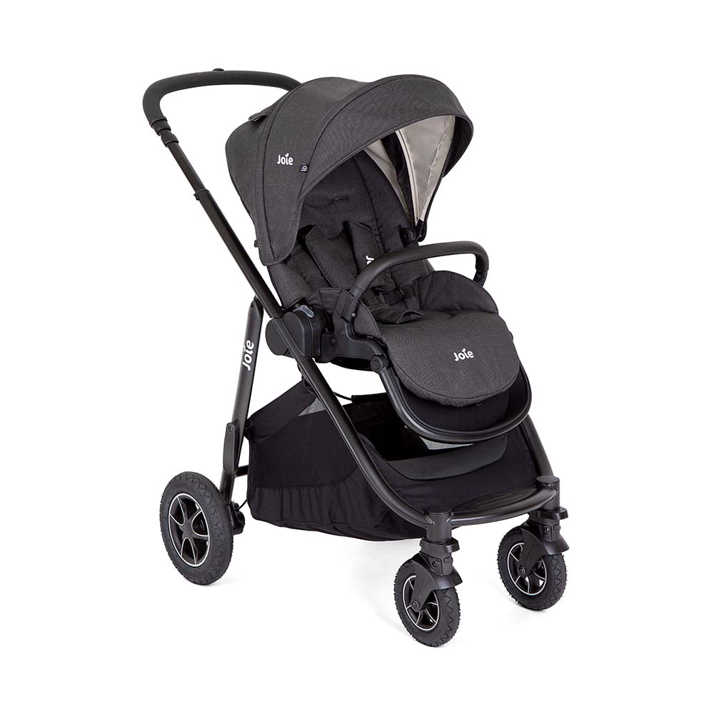 Detalhe da cesta porta-objetos grande do carrinho Joie Versatrax™, acessível pela frente, ideal para transportar artigos essenciais.